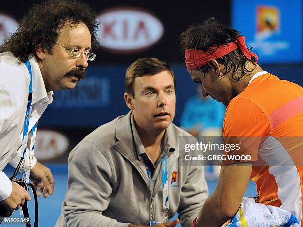 Courtside trainers look after Rafael Nadal of Spain after an injury to his knee while playing against Andy Murray of Britain in their men's singles...