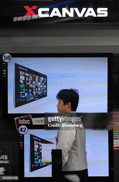 Sales clerk waits for customers in front of LG Electronics Inc. Television sets at an electronics shop in Seoul, South Korea, on Wednesday, Jan. 27,...