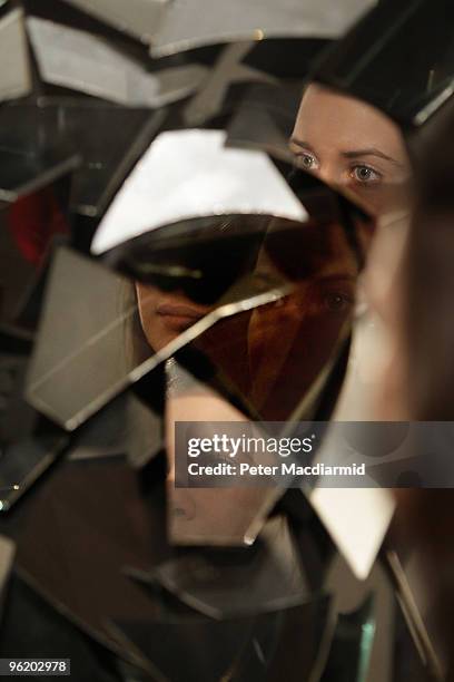 An employee is reflected in the broken mirrors of Christan Megert's 'Untitled 1962' on display at Sotheby's on January 27, 2010 in London, England....