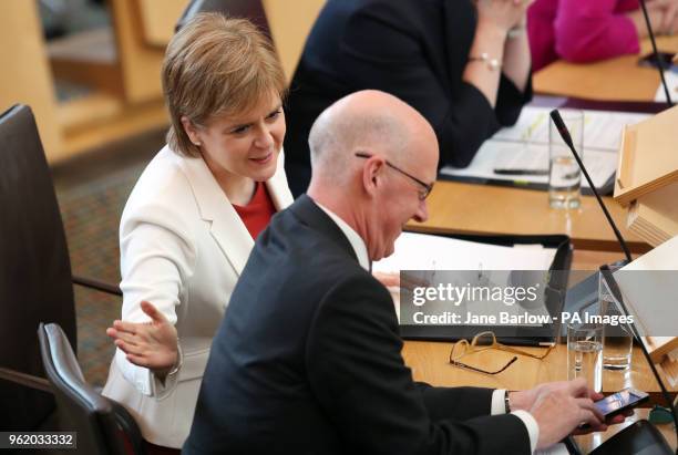 First Minister Nicola Sturgeon slaps the back of Deputy First Minister John Swinney during First Minister's Questions at the Scottish Parliament in...