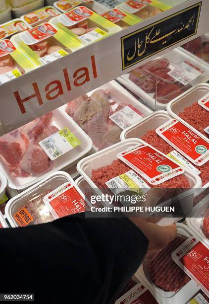 Woman shops in the Halal meat produce section of a Carrefour supermarket on March 15, 2012 in the French northern city of Hazebrouck. AFP PHOTO /...