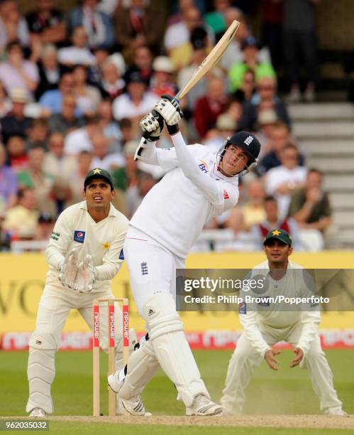 Stuart Broad of England hits a six watched by Pakistan's wicketkeeper Kamran Akmal and Imran Farhat during the 1st Test match between England and...
