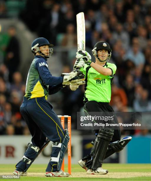 Steven Davies of Surrey hits out watched by Essex wicketkeeper James Foster during the Friends Provident T20 match between Surrey and Essex at The...