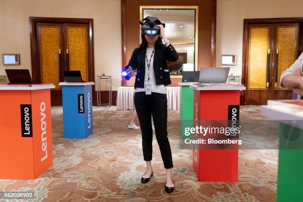 An attendee wears a Lenovo Group Ltd. Augmented reality headset while playing the 'Star Wars: Jedi Challenges' game at a news conference in Hong...