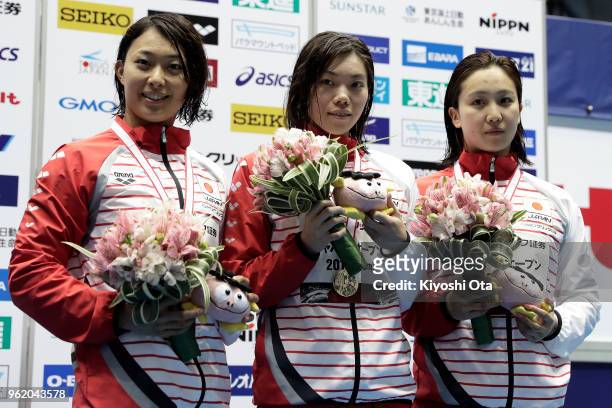 Winner Reona Aoki of Japan celebrates with runner-up Satomi Suzuki of Japan and third-placed Kanako Watanabe of Japan after the Women's 100m...