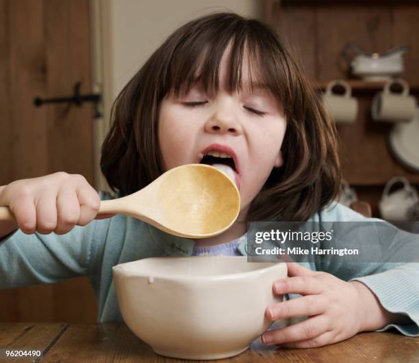 young girl licking spoon - genuss stock-fotos und bilder