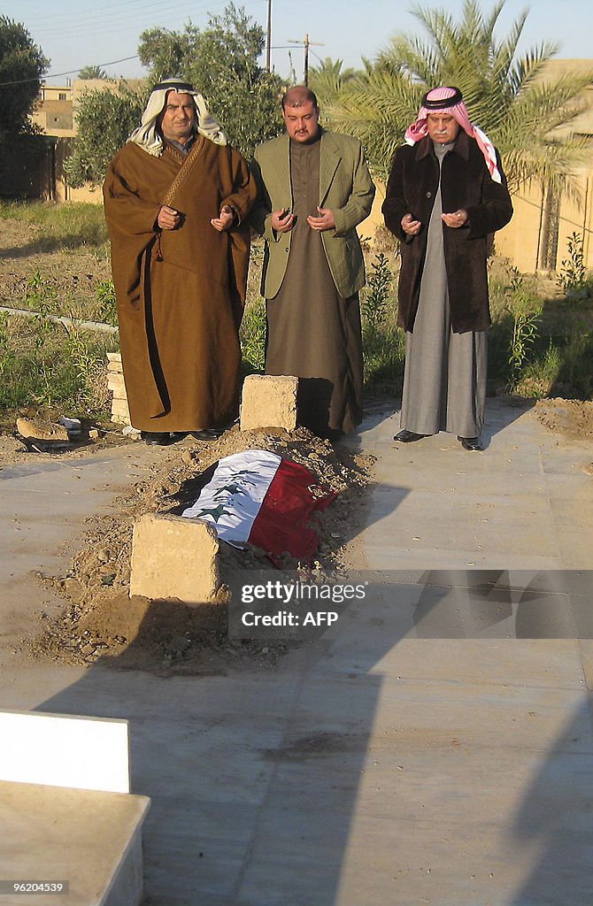 Mourners pray on January 27, 2010 over t