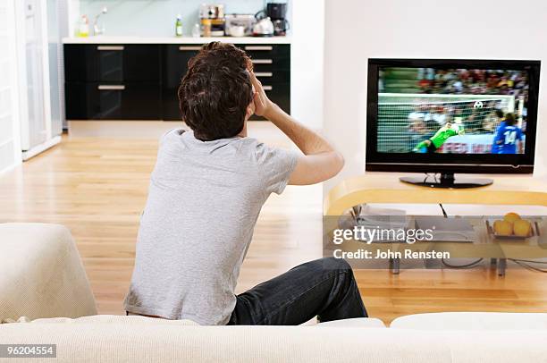 football fan covers eyes as goal scored on tv - sports man cave stock pictures, royalty-free photos & images