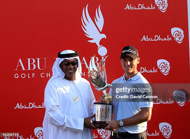 Martin Kaymer of Germany poses with the trophy and Ahmed Hussein the Deputy Director General for Tourism Operations Abu Dhabi Tourism Authority...