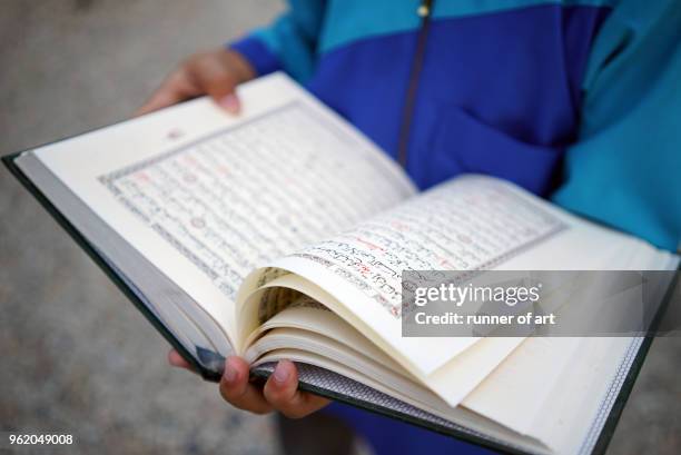 reading the quran - association of religion data archives stock pictures, royalty-free photos & images