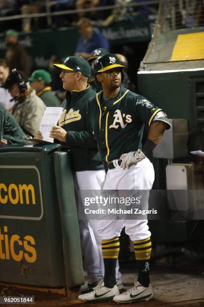 Hitting Coach Darren Bush and Khris Davis of the Oakland Athletics stand in the dugout during the game against the Houston Astros at the Oakland...