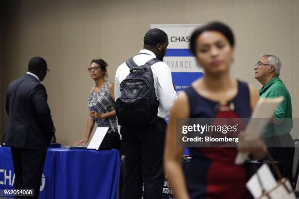 Job seekers speak with representatives during a National Career Fairs event in Tampa, Florida, U.S., on Wednesday, May 23, 2018. Filings for U.S....