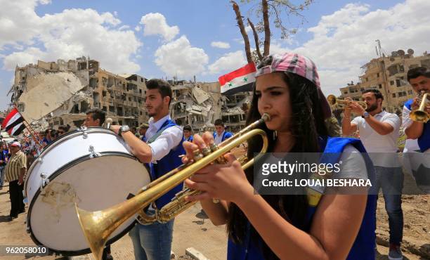 Members of the Revolutionary Youth Union, the youth organization of the Arab Socialist Baath Party in Syria, play musical instruments during a flag...