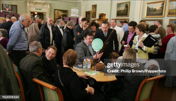 Sporting memorabilia expert David Convery examines an old cricket bat during a recording of Antiques Roadshow in the Long Room at Lord's Cricket...