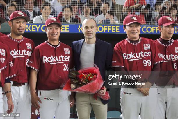 Andres Iniesta poses with Masataka Nashida , manager of the Japanese professional baseball team Rakuten Eagles, and other players at Tokyo Dome on...