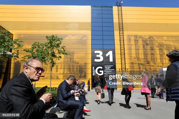 An attendee smokes a cigar in an outdoor area between panel debates at the St Petersburg International Economic Forum in Saint Petersburg, Russia, on...