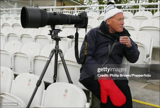 Photographer Patrick Eagar keeps warm with a cup of tea in the Compton Stand on the first day of the cricket season as MCC take on County champions...