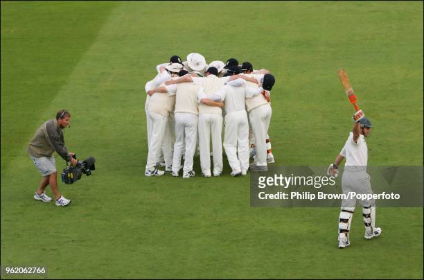 Television cameraman films the England team in a huddle as Adam Gilchrist of Australia walks out to bat during the 4th Test match between England and...