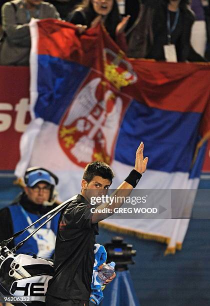 Supporters wave the Serbian flag as Novak Djokovic of Serbia waves goodbye following his loss to Jo-Wilfried Tsonga of France in their men's singles...