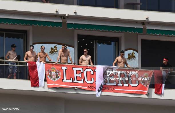 Supporters of Sauber F1's Monegasque driver Charles Leclerc stand with a banner on a balcony as they watch the second practice session at the Monaco...