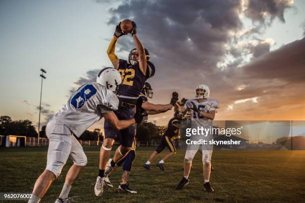american football quarterback catching the ball during a match. - receiver imagens e fotografias de stock