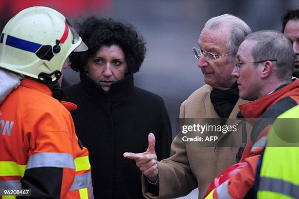 Belgium's King Albert II talks to a firefighter next to Interior Minister Annemie Turtelboom as he visits the site of a gas explosion in central...