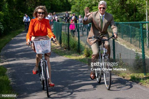 King Philippe of Belgium and Queen Mathilde ride a bike during a visit to the province of Limbour on May 24, 2018 in Limbourg, Belgium.
