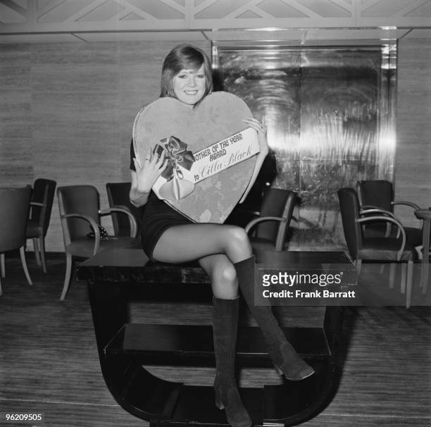 English singer Cilla Black at the Savoy Hotel, London, with a special presentation box of chocolates, her award after being chosen as the Mothers'...