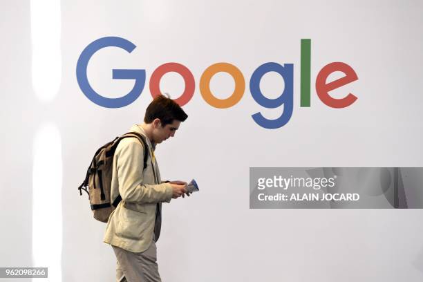 Man walks past the logo of the US multinational technology company Google during the VivaTech trade fair , on May 24, 2018 in Paris.