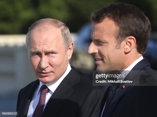 Russian President Vladimir Putin talks to French President Emmanuel Macron during their meeting at Konstantin Palace in Saint Petersburg Russia, May...