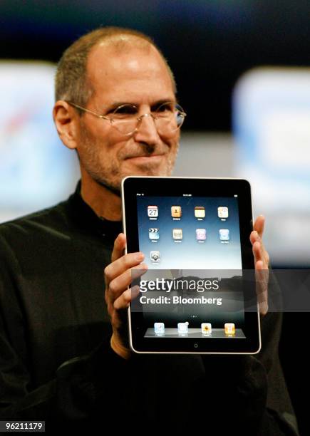 Steve Jobs, chief executive officer of Apple Inc., holds an Apple iPad tablet during its debut at the Yerba Buena Center for the Arts Theater in San...