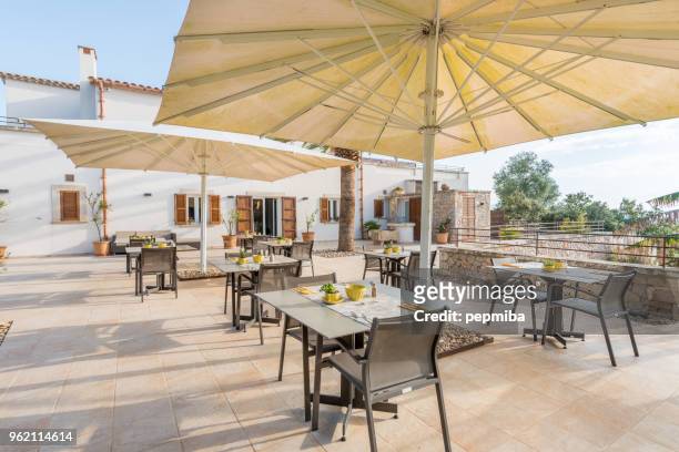 cafe tabellen uit hotel onder witte paraplu 's - terrace stockfoto's en -beelden