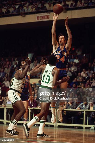 Bill Bradley of the New York Knicks shoots a jump shot against JoJo White of the Boston Celtics during a game played in 1972 at the Boston Garden in...