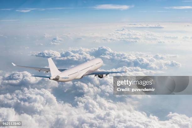 vliegtuig vliegen over bewolkte hemel - bovenop stockfoto's en -beelden