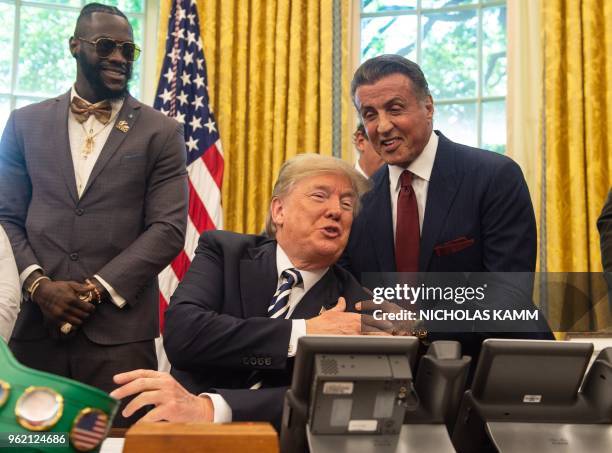 President Donald Trump jokes with actor Sylvester Stallone before signing a posthumous pardon for former world champion boxer Jack Johnson in the...