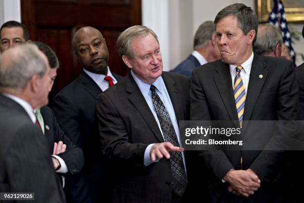 Senator Mike Crapo, a Republican from Idaho, center, and Senator Steve Daines, a Republican from Montana, right, attend a signing ceremony of S....