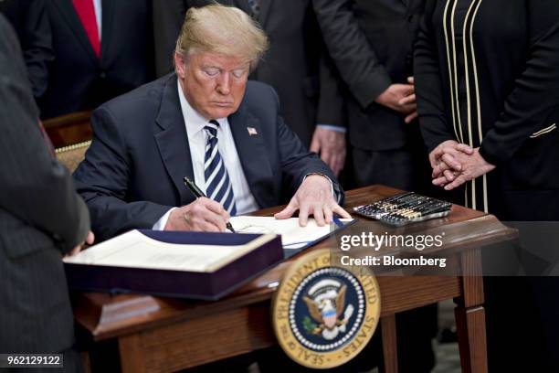 President Donald Trump, center, signs S. 2155, the Economic Growth, Regulatory Relief, And Consumer Protection Act, with administration officials and...