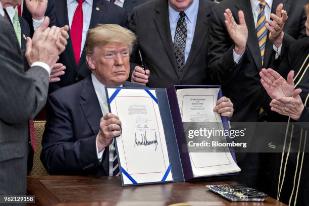 President Donald Trump, center, holds up S. 2155, the Economic Growth, Regulatory Relief, And Consumer Protection Act, after being signed with...