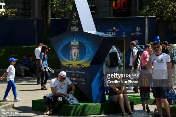 People sit at the shadow of star-shaped announcement of UCL Final at a fan zone in Kyiv, Ukraine, May 24, 2018. Official UEFA Champions League Final...
