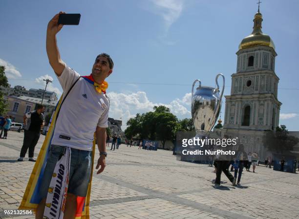 Real Madrid fan takes a selfie iin front of giant replica of the UEFA Champions League Cup set up near the Saint Sophia's Cathedral in Kyiv, Ukraine,...