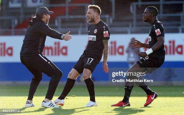 Maximilian Zimmer of Cottbus jubilates with team mate Kevin Weidlich and head coach Claus Dieter Wollitz after scoring the third goal during the...