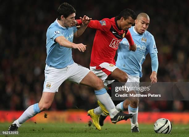 Nani of Manchester United clashes with Gareth Barry and Nigel De Jong of Manchester City during the Carling Cup Semi-Final Second Leg match between...