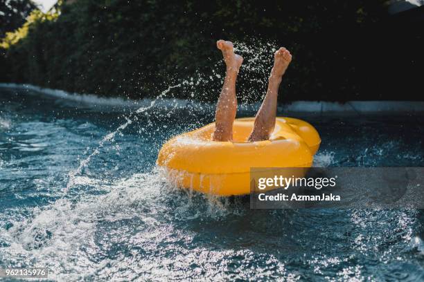 man valt in het water in het zwembad - water slide stockfoto's en -beelden