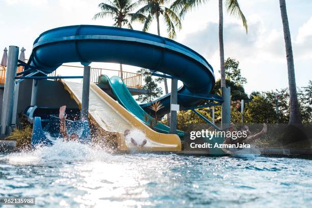 gens descendre les toboggans à un parc aquatique - slide photos et images de collection