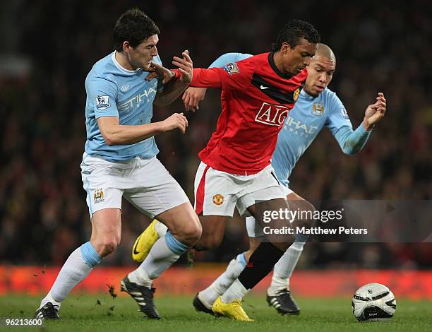 Nani of Manchester United clashes with Gareth Barry and Nigel De Jong of Manchester City during the Carling Cup Semi-Final Second Leg match between...