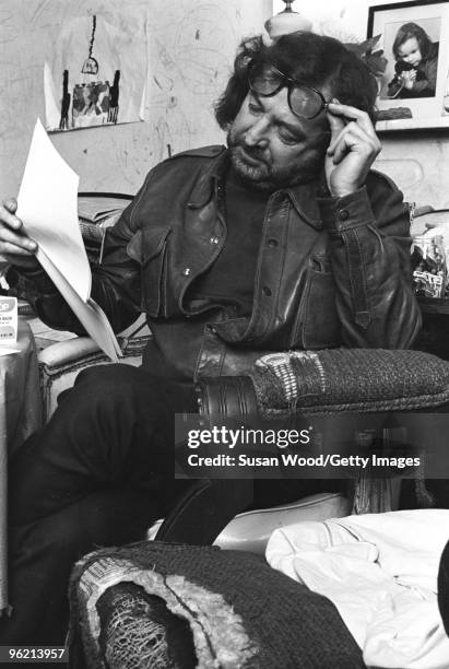 American author, screenwriter, and satirist Terry Southern holds up his sunglasses as he and actor Rip Torn work on the 'Easy Rider' script in Torn's...