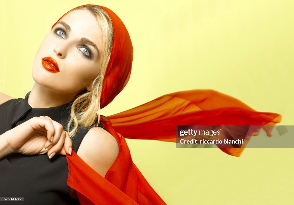 BLONDE WOMAN WITH RED LIPS AND SCARF ON YELLOW
