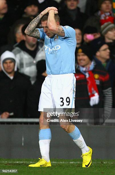 Craig Bellamy of Manchester City reacts after being hit by objects thrown from the crowd during the Carling Cup Semi Final second leg match between...