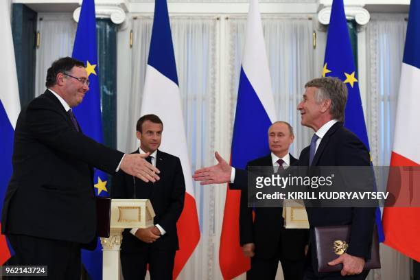 French oil giant Total Chief Executive Officer Patrick Pouyanne exchanges documents with Novatek chief Leonid Mikhelson as Russian President Vladimir...