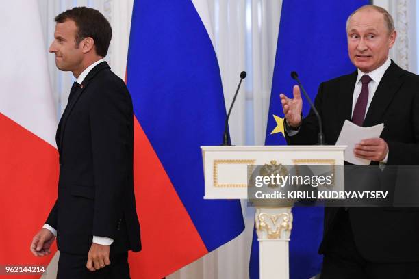 Russian President Vladimir Putin and his French counterpart Emmanuel Macron arrive to attend a signing ceremony following their talks at the...